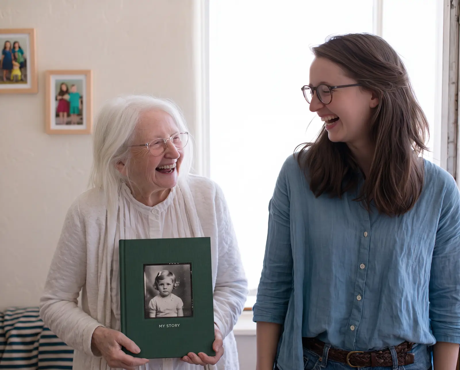 An older woman laughing with her daughter, holding a hardcover life story book