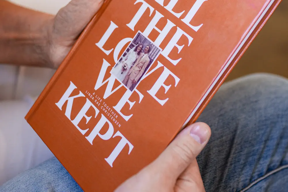 A finished Ethos hardcover held in one hand, its title and cover photo showing