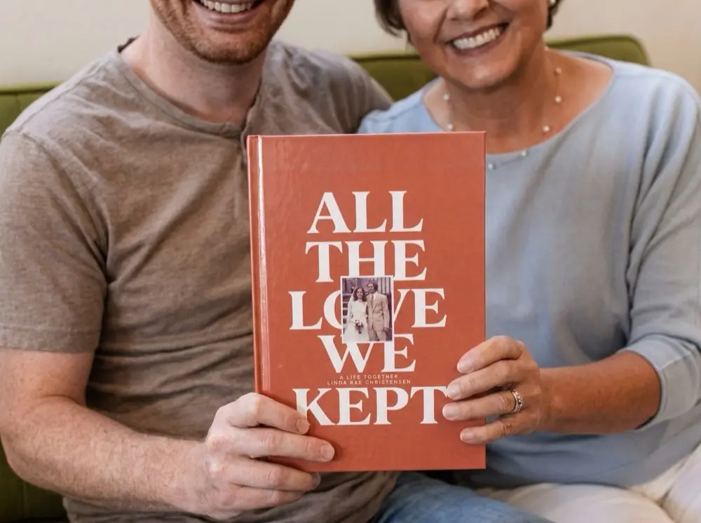 Two people smiling, holding a finished Ethos hardcover